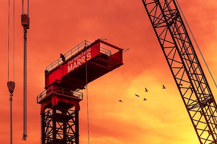 Construction crane against a sunset sky